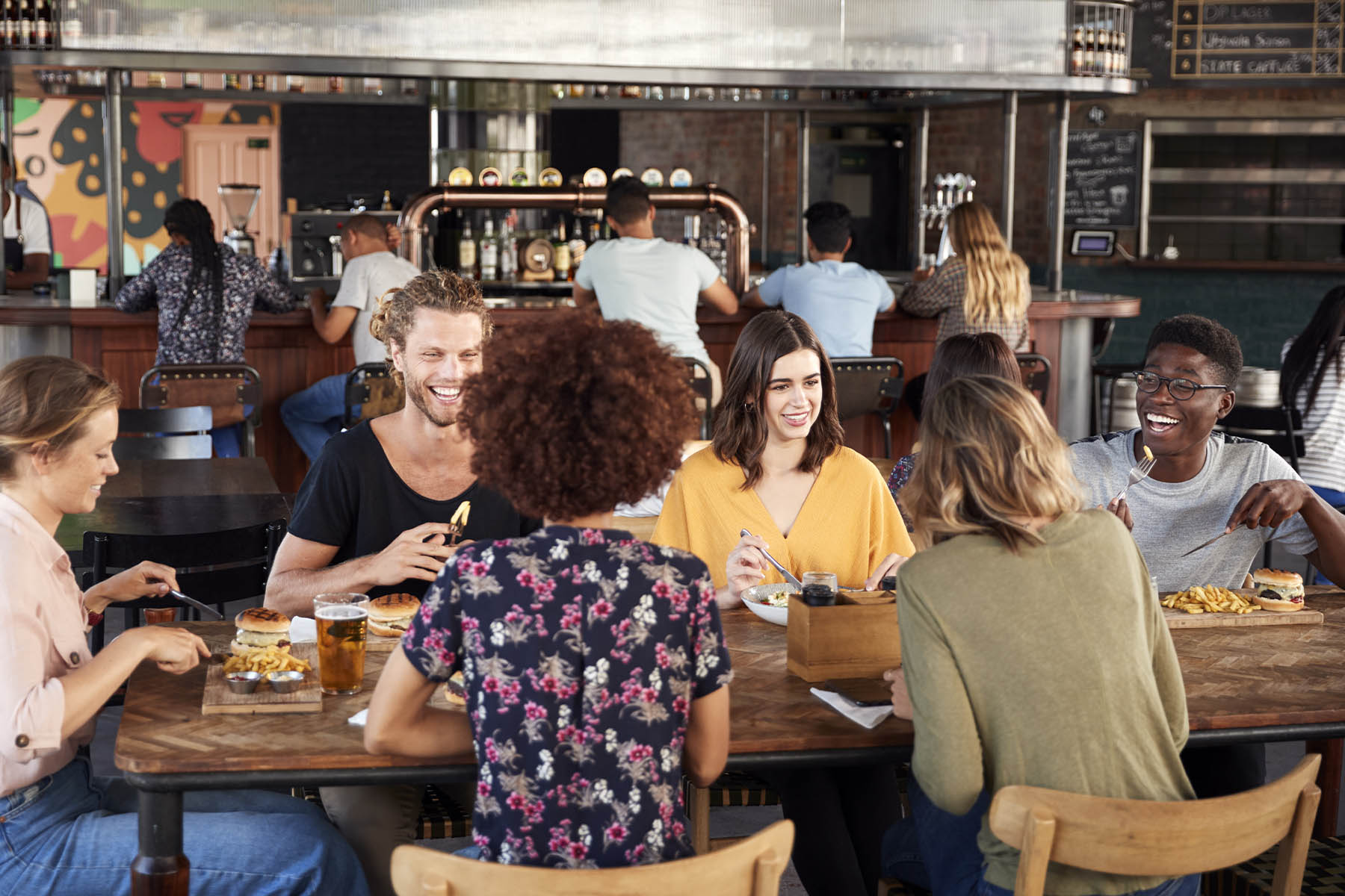 group of friends happily dining indoors at a bustling restaurant